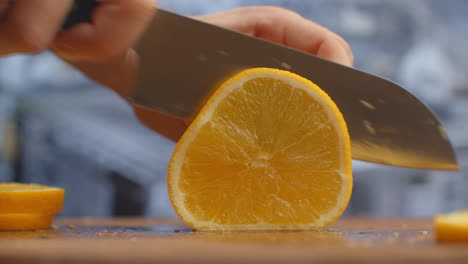 Close-up-of-cut-orange-on-a-board-in-the-kitchen-on-a-wooden-board